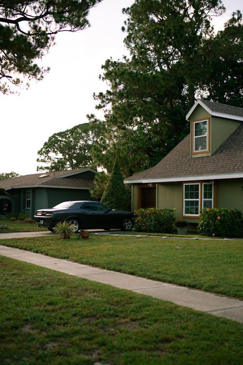 Residential house with a car parked in the driveway under a modern roof