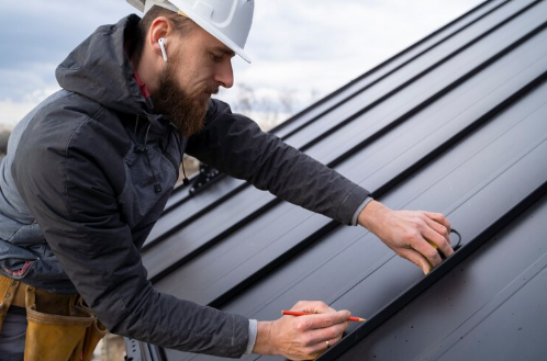 A person laying down roof panels.
