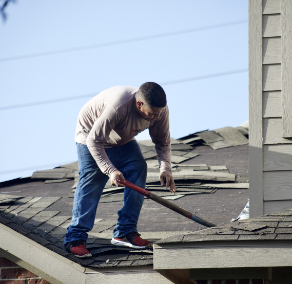 A person laying down a new roof on a house.