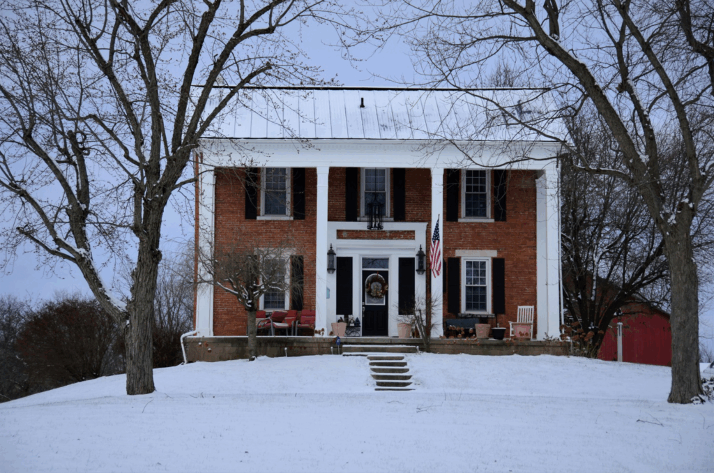 a house with a metal roof, surrounded by snow