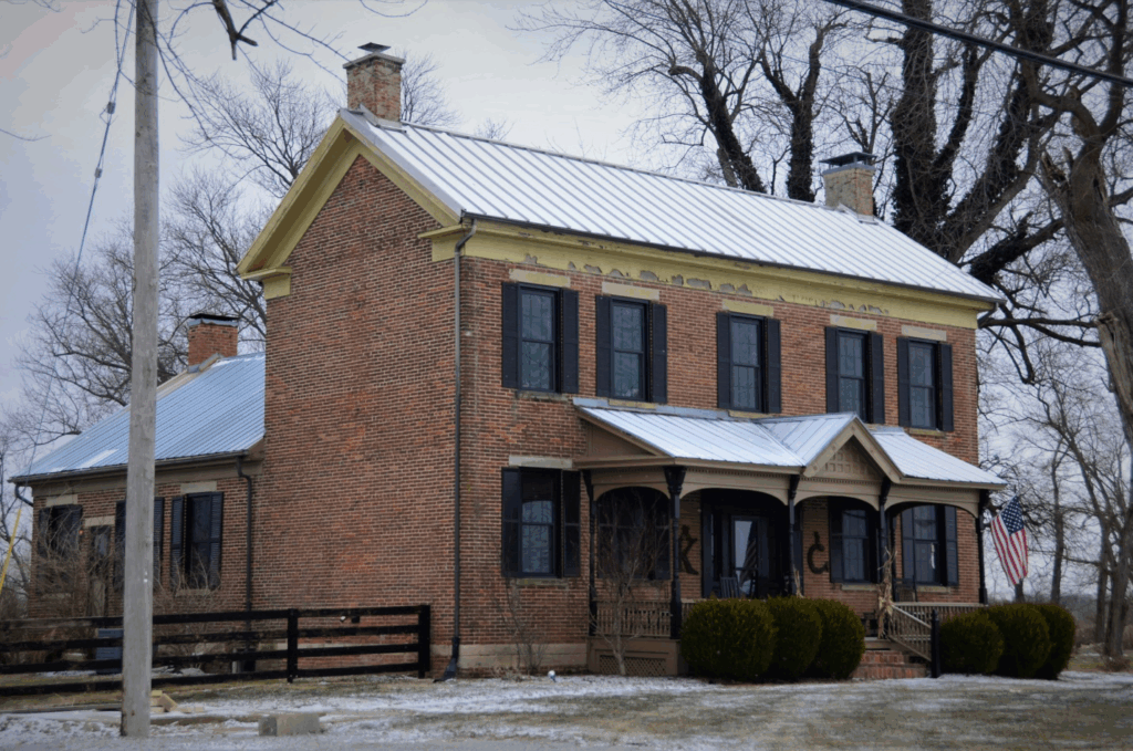 a red brick house with a metal roof