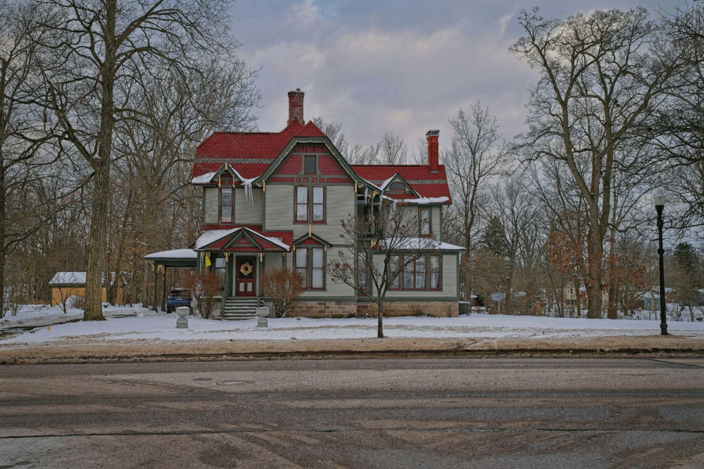 a snow-covered house with a red roof