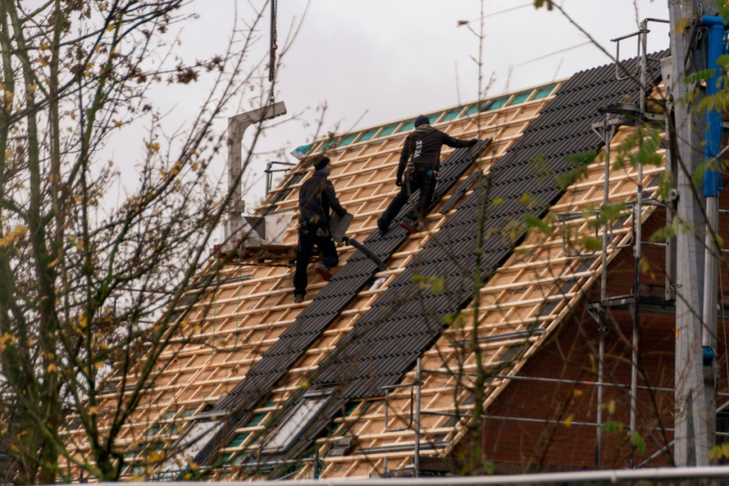 two roofers installing shingles after a roof inspection