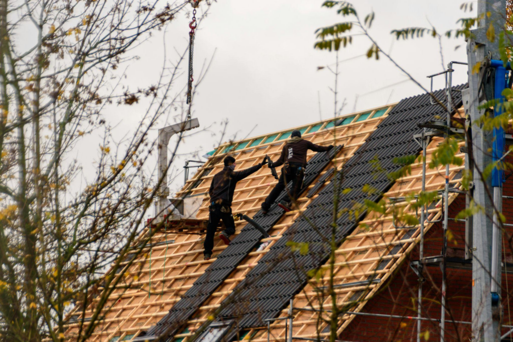 roofing contractors installing shingles over the roof underlayment