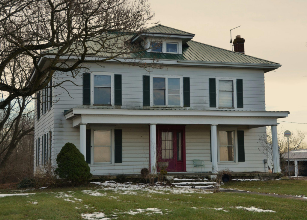 a white house with a colored metal roof