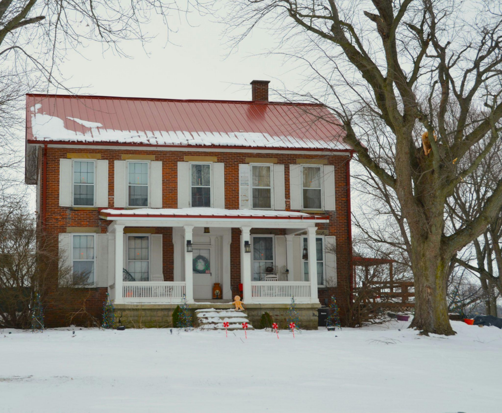 a red brick house with a red metal roof